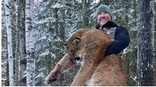 {picture of hunter holding dead cougar}